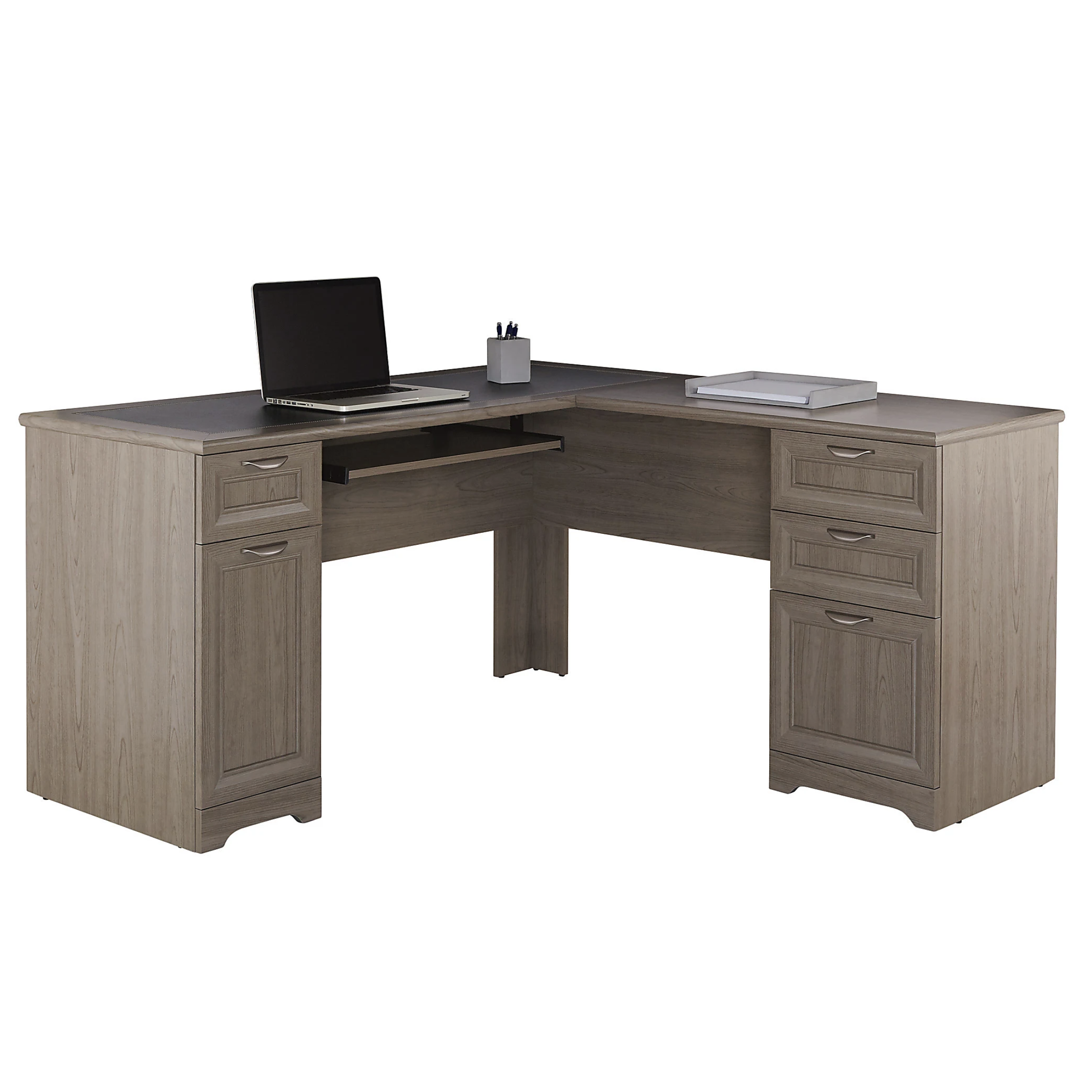 L-shaped wooden desk with a laptop, pen holder, and documents. Features multiple drawers and a pull-out keyboard tray.