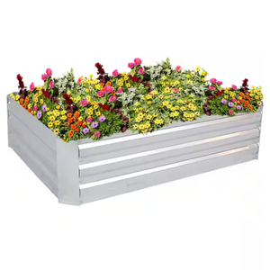 A metal raised garden bed filled with a variety of colorful flowers, including pink, yellow, orange, and white blooms.