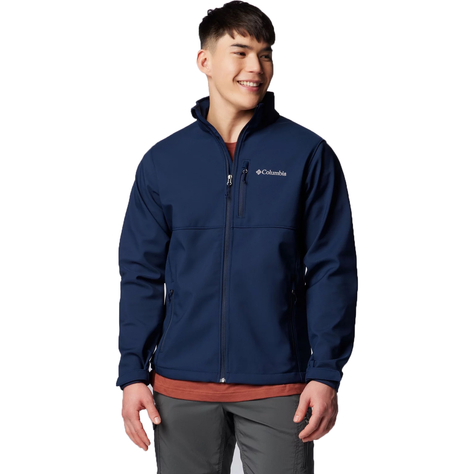 A person is wearing a blue Columbia branded softshell jacket with a full-length front zipper and side pockets.