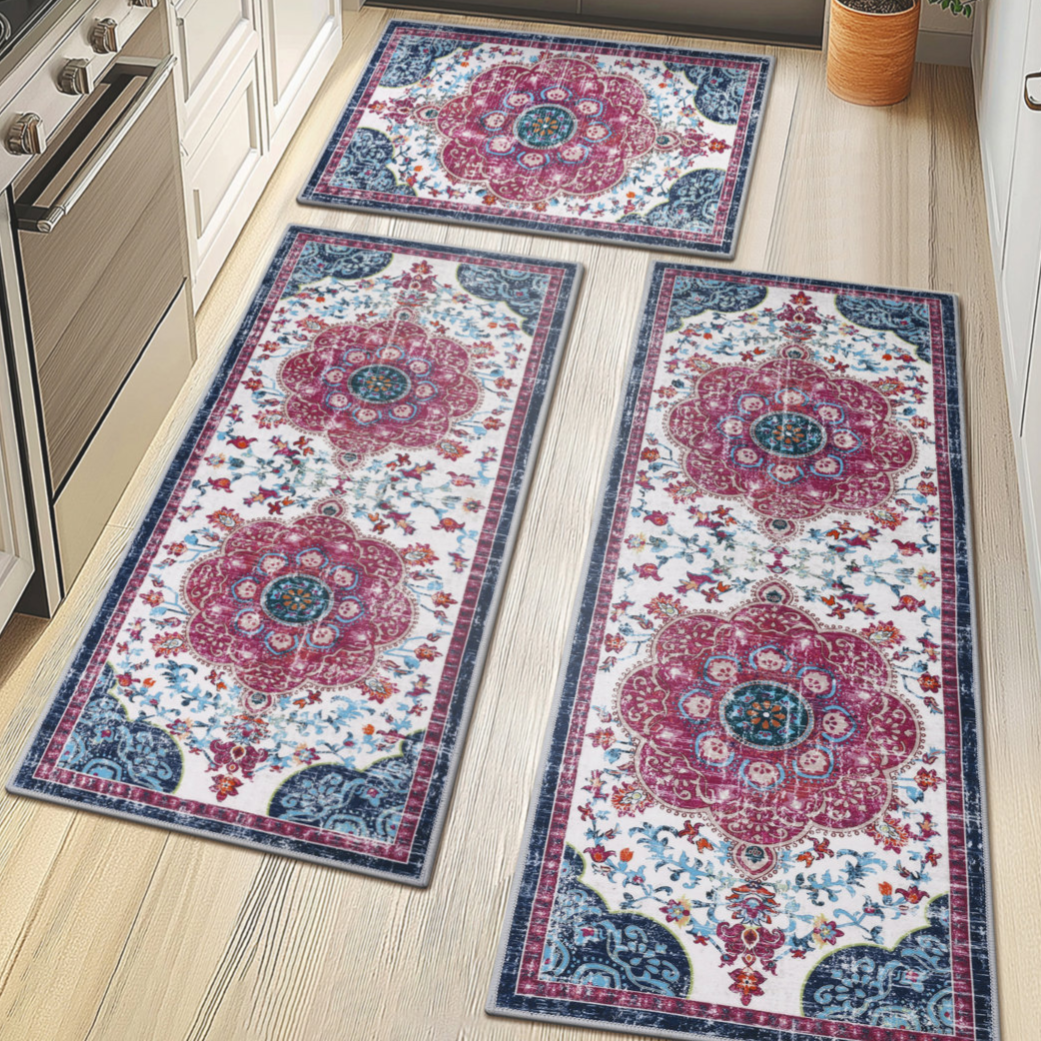 Three oriental-style runner rugs with floral patterns in red, blue, and white are displayed on a light wood kitchen floor, surrounded by white cabinetry and a stainless steel stove.