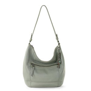 A light grey shoulder bag with an exterior zip pocket and a decorative chain charm.