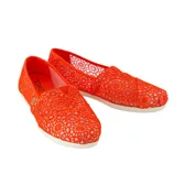 Bright orange crochet slip-on shoes with floral patterns and white soles, featuring the TOMS logo on the insole.