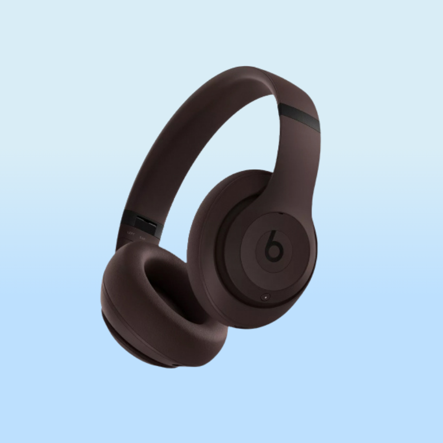 A pair of over-ear Beats headphones in a dark brown color with a minimalist design featuring a prominent \“b\“ logo on the ear cup.