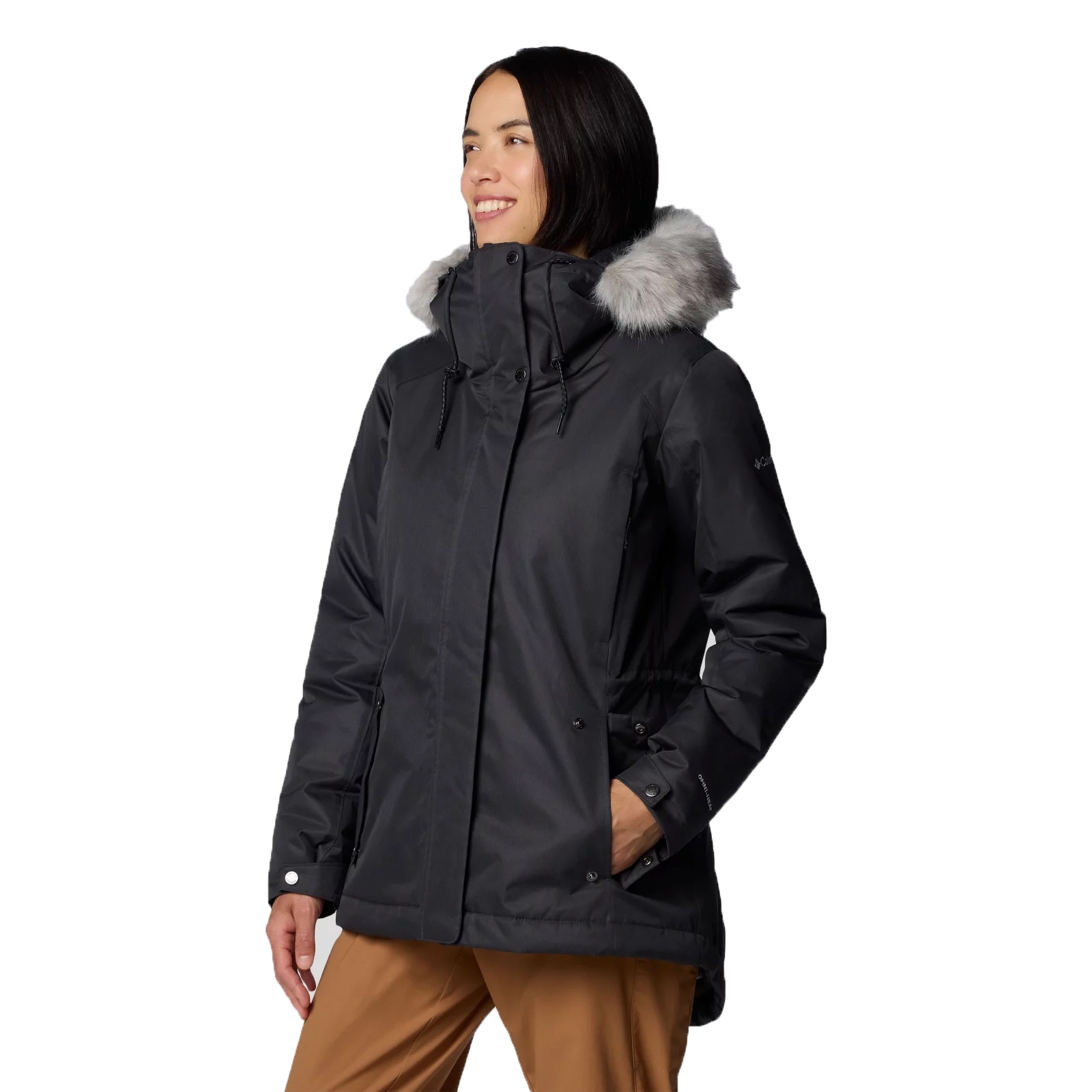 A black winter jacket with a faux fur-trimmed hood, worn by a person dressed in tan pants.