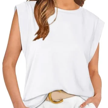 A woman wears a sleeveless white top with rolled cuffs, paired with light-colored pants and a wide belt featuring a large oval buckle.