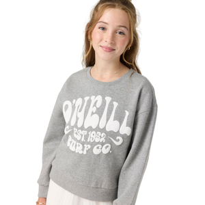 A young girl is wearing a gray sweatshirt with \“O'Neill Surf Co. Est. 1952\“ printed on it, paired with white wide-legged pants and sandals.