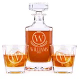 A personalized whiskey decanter set includes a square glass decanter and two matching glasses with an engraved \“WILLAMS 2022\“ and \“W\“ monogram.
