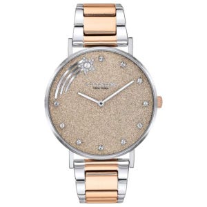 The COACH Perry watch features a gold-tone glitter dial with crystal accents and a shooting star design. It has a two-tone stainless steel bracelet, combining silver and rose gold hues.