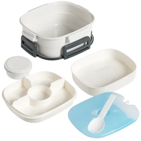 A five-piece bento lunch box set including a container, a lid, a smaller round container, a divided tray, and a spork resting on a blue tray.