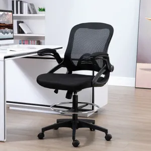 A black mesh ergonomic office chair with adjustable armrests, caster wheels, and a footring, positioned next to a white desk in a modern workspace.