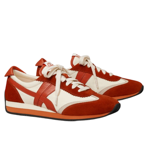 Red and white sneakers with a retro design, featuring suede and leather materials, white laces, and a black sole with red accents.
