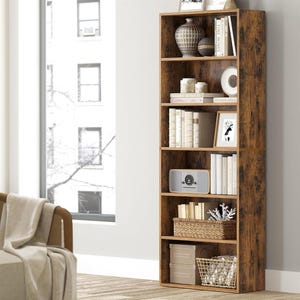 A tall wooden bookshelf with various decorative items and books, placed next to a window in a bright room.