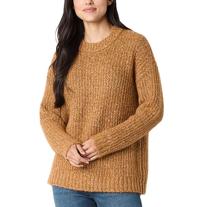 A woman is wearing a textured, camel-colored knit sweater with long sleeves and a round neckline, paired with blue jeans.