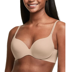 A woman wearing a seamless, nude-colored bra with adjustable straps.