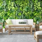 A living room set including a wooden sofa, armchairs, coffee table, and side table, accentuated with green cushions and vases against a vibrant green leafy wallpaper.