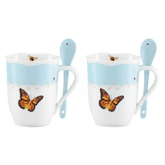 Two ceramic mugs with butterfly designs, accompanied by matching spoons. They feature a sky-blue top band with floral details.