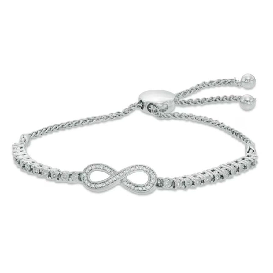 A silver-toned adjustable bracelet featuring an infinity symbol adorned with small clear stones, complemented by a chain and sliding closure with bead accents.