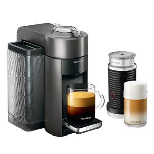 Nespresso coffee maker with Aeroccino milk frother, featuring a dark gray design and preparing a coffee and milk beverage.