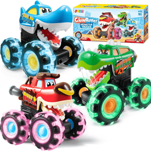 Toy monster trucks with colorful, light-up wheels featuring designs resembling a shark, bull, and dinosaur. Box labeled \“GlowRover Monster Trucks\“ for ages 18 months and up.