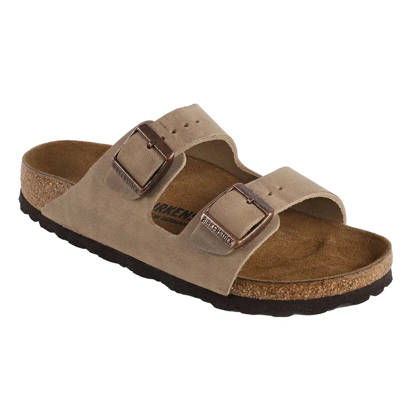 A beige Birkenstock sandal featuring the iconic two-strap design with adjustable metal buckles, cork footbed, and black rubber outsole.