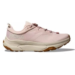 Hoka Transport Running Shoes feature a light pink color with contrasting gum-colored soles. The design includes prominent Hoka branding and a Vibram sole for enhanced traction, providing a combination of style and functionality for runners.