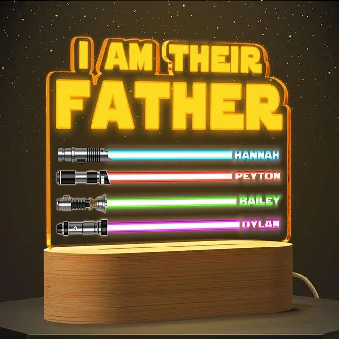 A light-up display with a Star Wars theme, saying \“I Am Their Father,\“ features four lightsaber designs in different colors, each labeled with names: Hannah, Peyton, Bailey, and Dylan.