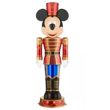 A figurine resembling a classic cartoon character dressed as a nutcracker soldier, featuring a red and gold uniform with blue pants and a tall red hat.