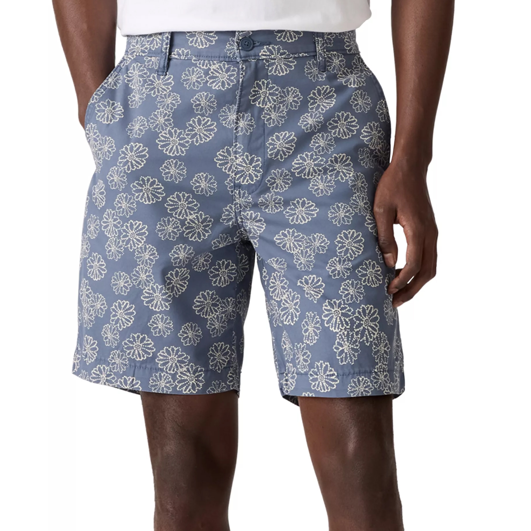 Blue shorts with a white floral pattern, paired with a white shirt, featuring side pockets and a button closure.