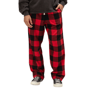 Red and black checkered pajama pants paired with black sneakers and a dark long-sleeve shirt.