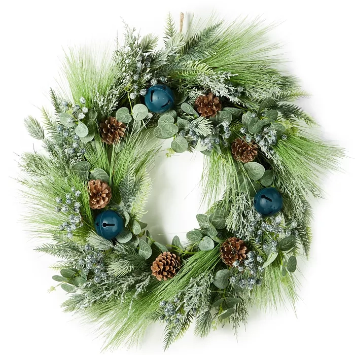 A lush wreath featuring green foliage, pine cones, blue berries, and large blue bells. The design combines various textures and shades of green for a festive look.