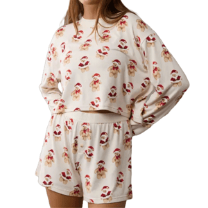 A cozy pajama set featuring a cream background with smiling teddy bears in Santa hats. Includes a long-sleeved top and matching shorts.