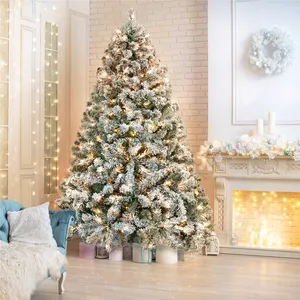 A snow-flocked Christmas tree with warm white lights stands near a fireplace adorned with candles and garland. A cozy armchair with a throw complements the festive decor.