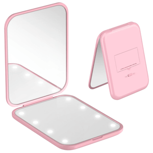A pink folding vanity mirror with LED lights, featuring a rectangular shape and a stand for adjustable angles.