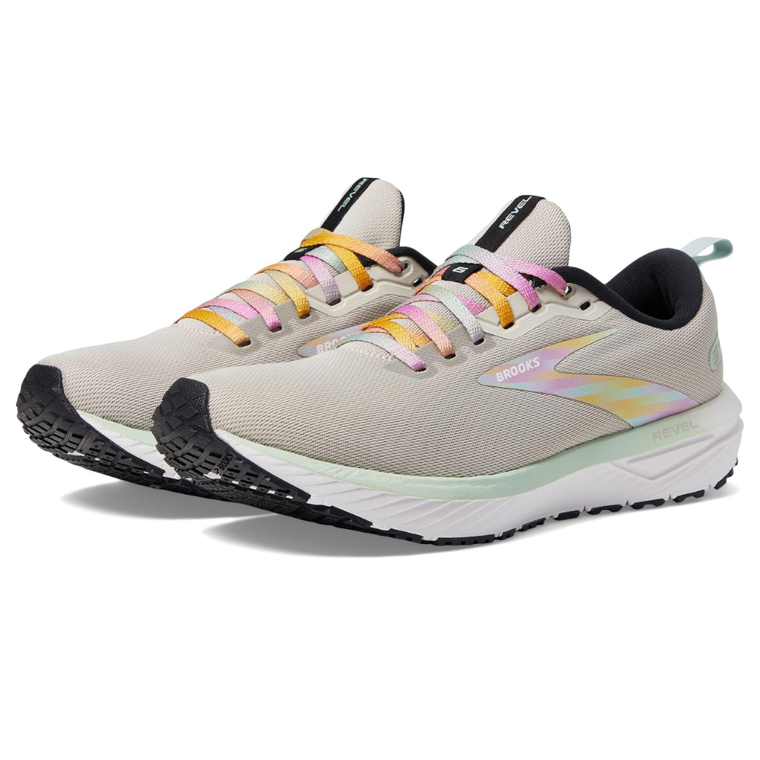 A pair of beige running shoes with multicolored laces and reflective accents.