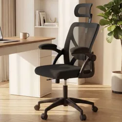 VASAGLE office chair with mesh design and adjustable armrests is placed by a wooden desk featuring a laptop and a lamp, set in a modern office space with light curtains and a potted plant.