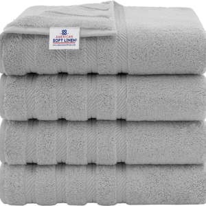 A stack of four light gray towels with a label reading \“American Soft Linen.\“