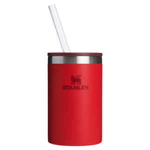 Red Stanley 10oz Can Cooler Cup with a straw, featuring a winged lion logo. Made of insulated stainless steel, it keeps drinks cold and fits most cans securely.