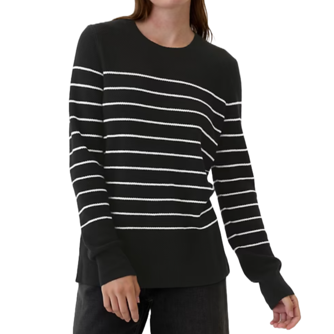 Black long-sleeve sweater with white horizontal stripes and a round neckline. Worn with dark pants.