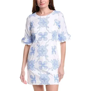 A white dress with blue floral patterns, featuring short ruffled sleeves and a round neckline.