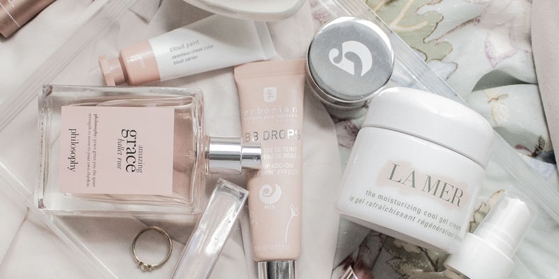 assorted pink and white high-end beauty products displayed on a counter