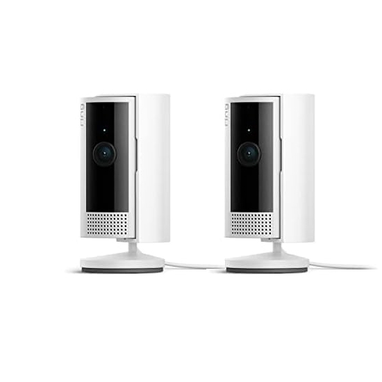 Two white Ring Indoor Cameras with black fronts, featuring a lens and speaker grill on each. They are mounted on small circular bases. These cameras are designed for indoor video monitoring.