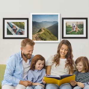 Three framed prints hang on the wall: one features children in a hammock, the second showcases a scenic mountain landscape, and the third depicts a happy dog outdoors.