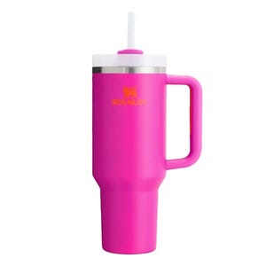 A pink insulated tumbler with a handle and a lid featuring a straw, designed to keep beverages hot or cold.