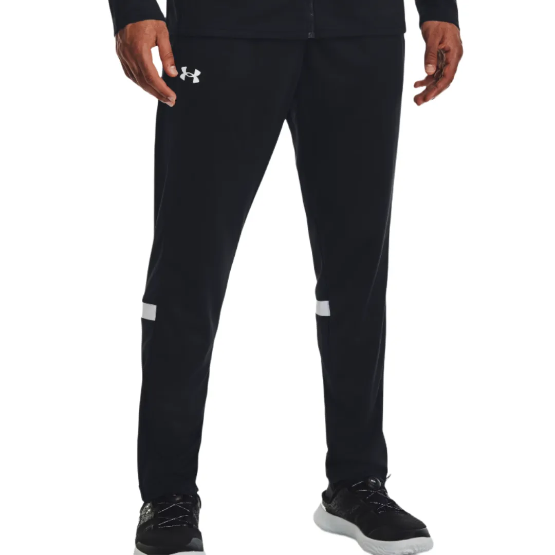 Black athletic track pants with the Under Armour logo on the upper left thigh, featuring white stripes above the knees, paired with black athletic shoes with white soles.