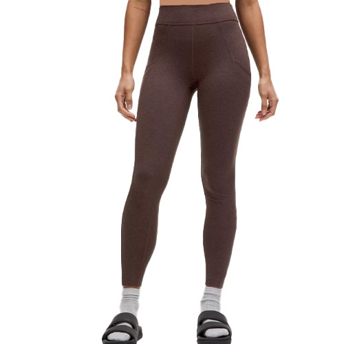 Lululemon Suedey High-Rise Leggings are brown high-waisted leggings with a smooth, suede-like texture. They feature pockets and are paired with white socks and black sandals.