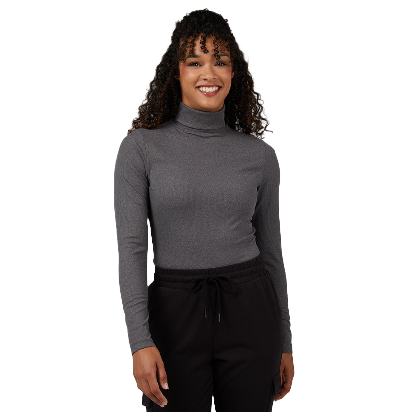 A person wearing a gray turtleneck and black drawstring pants, smiling.