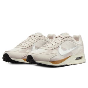 Nike sneakers in light beige with a visible Air Max unit, featuring a white swoosh and black outsole.