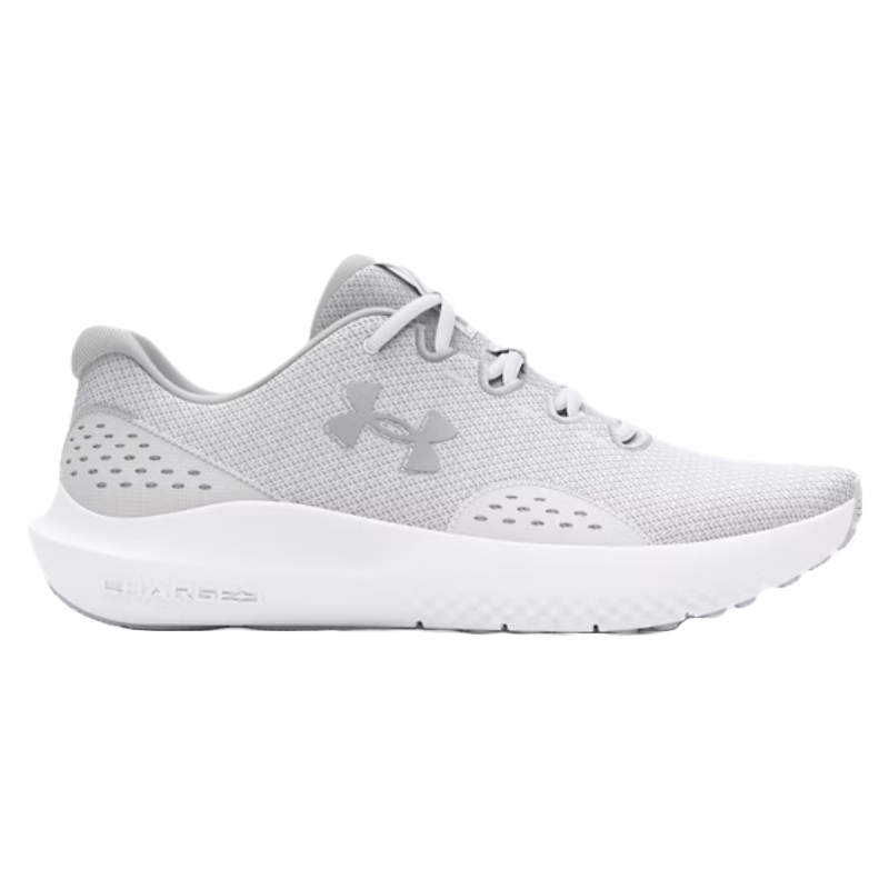 A gray Under Armour athletic shoe with a white sole, featuring mesh upper for breathability and the brand's logo on the side. The sole includes \“Charged\“ cushioning technology for enhanced comfort.
