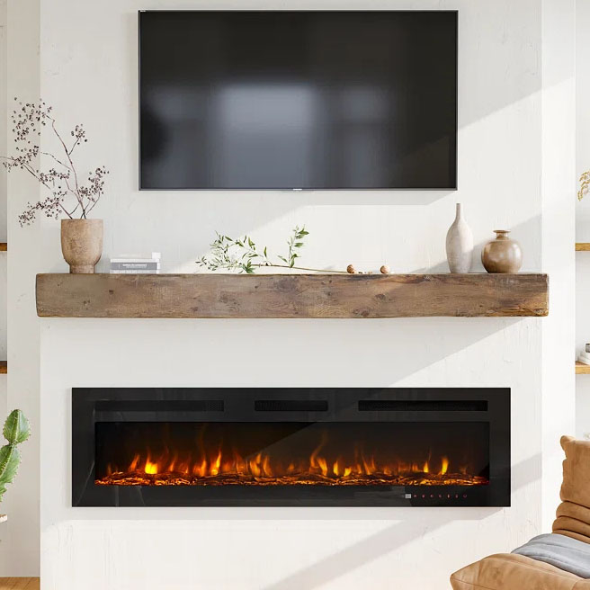 A modern, thin, wall-mounted electric fireplace emits a cozy, artificial flame effect below a television. Decorative items are displayed on a rustic wooden mantel above.