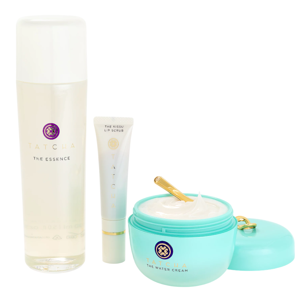 Tatcha skincare set includes The Essence, The Kissu Lip Scrub, and The Water Cream with a gold spatula.